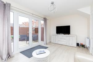 a living room with a tv and a large window at Wakefield 4 Bed - Parking, Self Check-in, Fast WiFi, Near Centre, Motorway Access - Contractors, Families, Long Stays in Wakefield