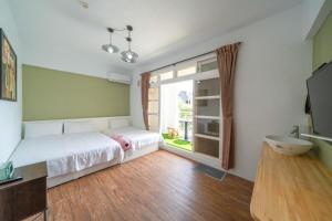 Un dormitorio con una cama y una ventana grande. en GREEN INN, en Wujie