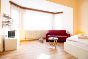 a living room with a red couch and a table at Burg Rotraut #4 in Ostseebad Sellin