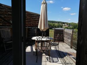 eine Terrasse mit einem Tisch und einem Sonnenschirm in der Unterkunft Ferienhaus Deko-Scheune in Naila