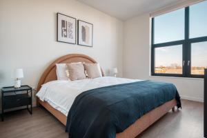 une chambre avec un grand lit et une fenêtre dans l'établissement Logan Square 2br w pool lounge gym nr L CHI-869, à Chicago