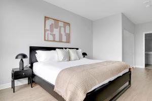 a white bedroom with a large bed and a table at Arlington Heights 2BR w Gym WD nr I-90 CHI-687 in Arlington Heights