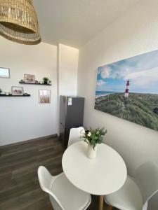 ヴィルヘルムスハーフェンにあるFeWo Muschelの灯台付きの部屋の白いテーブルと椅子 +5枚の写真