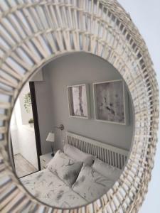 een spiegel die een slaapkamer reflecteert met een bed erin bij Vacacional Buyma - Parking privado -GRATUITO- in Málaga