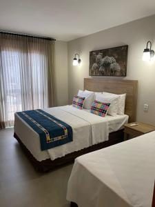 ein Schlafzimmer mit einem großen Bett mit zwei Kissen in der Unterkunft Quinta Santa Bárbara ECORESORT in Pirenópolis