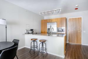 a kitchen with a counter with stools and a table at Streeterville 1br w pool gym nr Riverwalk CHI-878 in Chicago