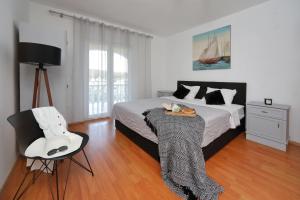 a bedroom with a bed with a table and a chair at Apartment Simunic Punta in Bibinje