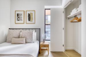 biała sypialnia z łóżkiem i stołem w obiekcie Downtown Brooklyn 2BR w WD nr Barclays Center NYC-657 w mieście Brooklyn