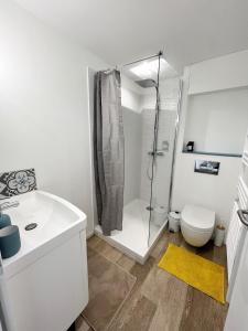 ein weißes Bad mit einer Dusche und einem WC in der Unterkunft Le Petit Canada - Proche ville in La Rochelle