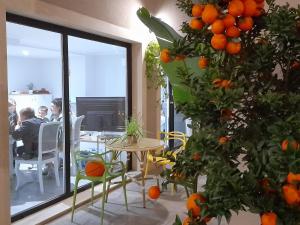 a room with an orange tree with a table and chairs at Mar Apartments Alicante in Playa de San Juan
