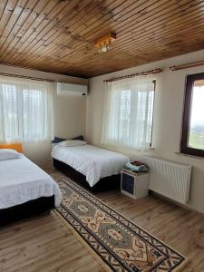 a bedroom with two beds and a rug at Trabzon Deniz Manzaralı villa in Araklı