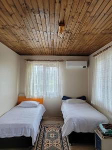 a bedroom with two beds and a wooden ceiling at Trabzon Deniz Manzaralı villa in Araklı