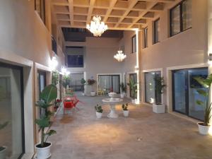 un grand hall avec des plantes en pot et des lustres dans l'établissement Mar Apartments Alicante, à Playa de San Juan