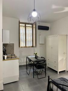 een keuken met een tafel en een kleine tafel in een kamer bij Figurari Home Napoli-2 in Napels