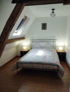 a bedroom with a bed in a attic at La Ferme de Frévan in Sarceaux