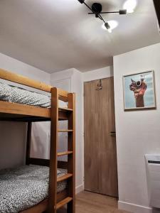 sypialnia z 2 łóżkami piętrowymi i wentylatorem sufitowym w obiekcie L’escute n°5 w mieście Houlle