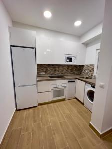 - une cuisine avec des placards blancs et un lave-linge/sèche-linge dans l'établissement RockSide Residences Suites La Línea N2, à La Línea de la Concepción