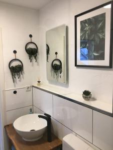 een witte badkamer met een wastafel en een spiegel bij Gemütliches Apartment am Kurhaus in Dobel in Dobel
