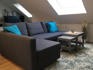 een woonkamer met een blauwe bank en een tafel bij Gemütliches Apartment am Kurhaus in Dobel in Dobel