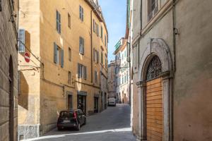 an alley with a car parked on a street between buildings at Affaccio sul Castellare in Siena