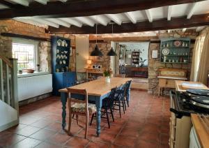 a large kitchen with a wooden table and chairs at Little Underhill in Oswestry