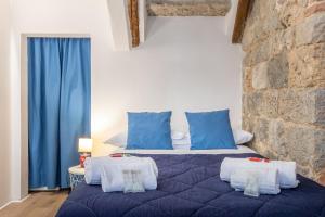 a bedroom with a blue bed with blue pillows at Affaccio sul Castellare in Siena