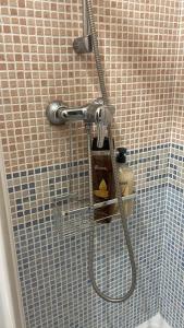 una ducha con una manguera pegada a una pared de azulejos en Casa San Marcos, en El Hornillo