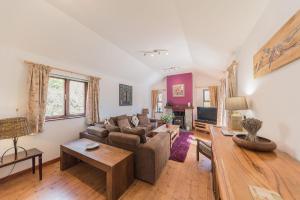 a living room with a couch and a table at Byre & Millers Woodland Coniston Sleeps 12 in Torver