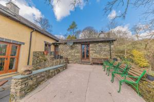 a group of green benches in front of a building at Byre & Millers Woodland Coniston Sleeps 12 in Torver