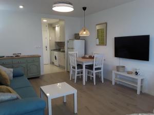 un soggiorno con divano e tavolo con sedie di Algaida New Studio Calahonda, Beach, Pools and Garden a Sitio de Calahonda