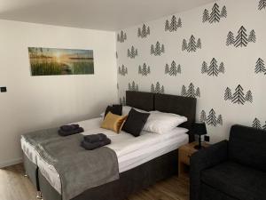 ein Schlafzimmer mit einem Bett und einem Sofa in einem Zimmer in der Unterkunft Apartamenty Leśna Plaża in Brenno