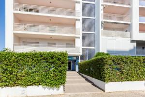 um edifício de apartamentos com sebes verdes em frente em Solemar - 2Pools - WIFI 500MBps - AC - Portimão em Portimão