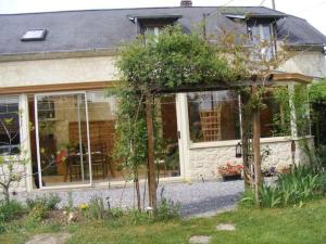 a house with glass doors and a garden at Au Moulin de la Tour in La Malmaison