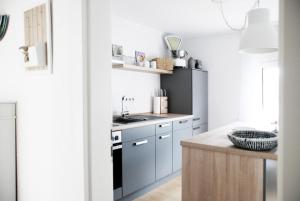 a kitchen with blue cabinets and a sink at LUX Ferienwohnung im Weinort Pommern an der Mosel in Pommern
