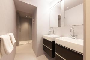 ein Badezimmer mit 2 Waschbecken und einem Spiegel in der Unterkunft Krone Säumerei am Inn in La Punt-Chamues-ch