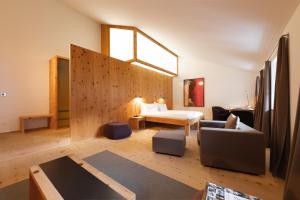 ein Wohnzimmer mit einem Sofa und einem Bett in einem Zimmer in der Unterkunft Krone Säumerei am Inn in La Punt-Chamues-ch