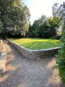 un muro di pietra in un parco con un prato di Victorian Villa a New Ross