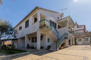 Una gran casa blanca con escaleras. en Apartments Crevatin, en Rovinj