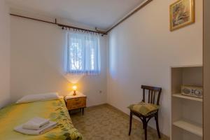 1 dormitorio pequeño con 1 cama y 1 silla en Apartments Crevatin, en Rovinj