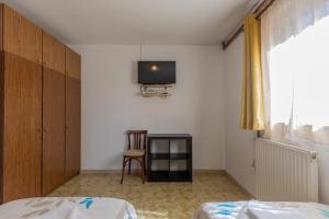 1 dormitorio con 1 cama y TV en la pared en Apartments Crevatin, en Rovinj
