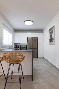 a kitchen with a counter and a chair in it at O&O Group - Luxury APT/3 BR/New Tower/Parking in Or Yehuda