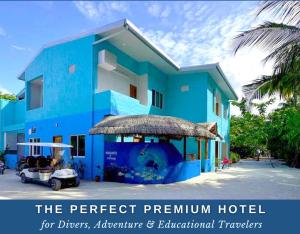 福拉杜島的住宿－Island Luxury Dive Hotel - Fulhadhoo，前面有高尔夫球车的蓝色建筑