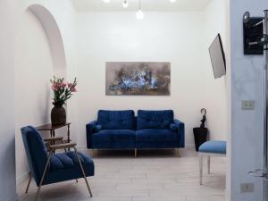 a living room with a blue couch and two chairs at La Sapienza APT in Rome