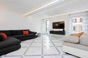 a living room with a couch and a tv at Exclusive Apartment Spagna View on Spanish Square in Rome