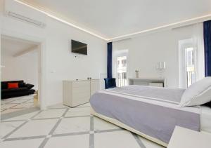 a white bedroom with a large bed and a living room at Exclusive Apartment Spagna View on Spanish Square in Rome