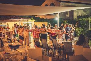 a group of people standing around in a restaurant at Erosea Beach Resort in Kavos