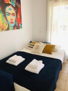 1 dormitorio con 1 cama grande y toallas. en Apartment Casa Lila 100m from the beach, en Torrox Costa