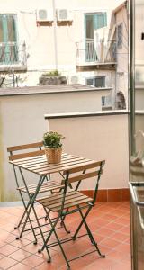 einem Picknicktisch mit Topfpflanze auf dem Balkon in der Unterkunft Al centro storico Home in Salerno + 14 Fotos
