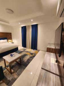 ein Hotelzimmer mit einem Bett und einem Couchtisch in der Unterkunft Sama Residence in Khobar