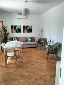 een woonkamer met een bank en een tafel en stoelen bij 2 Quinta Lamy - Casas & Papéis in Porches